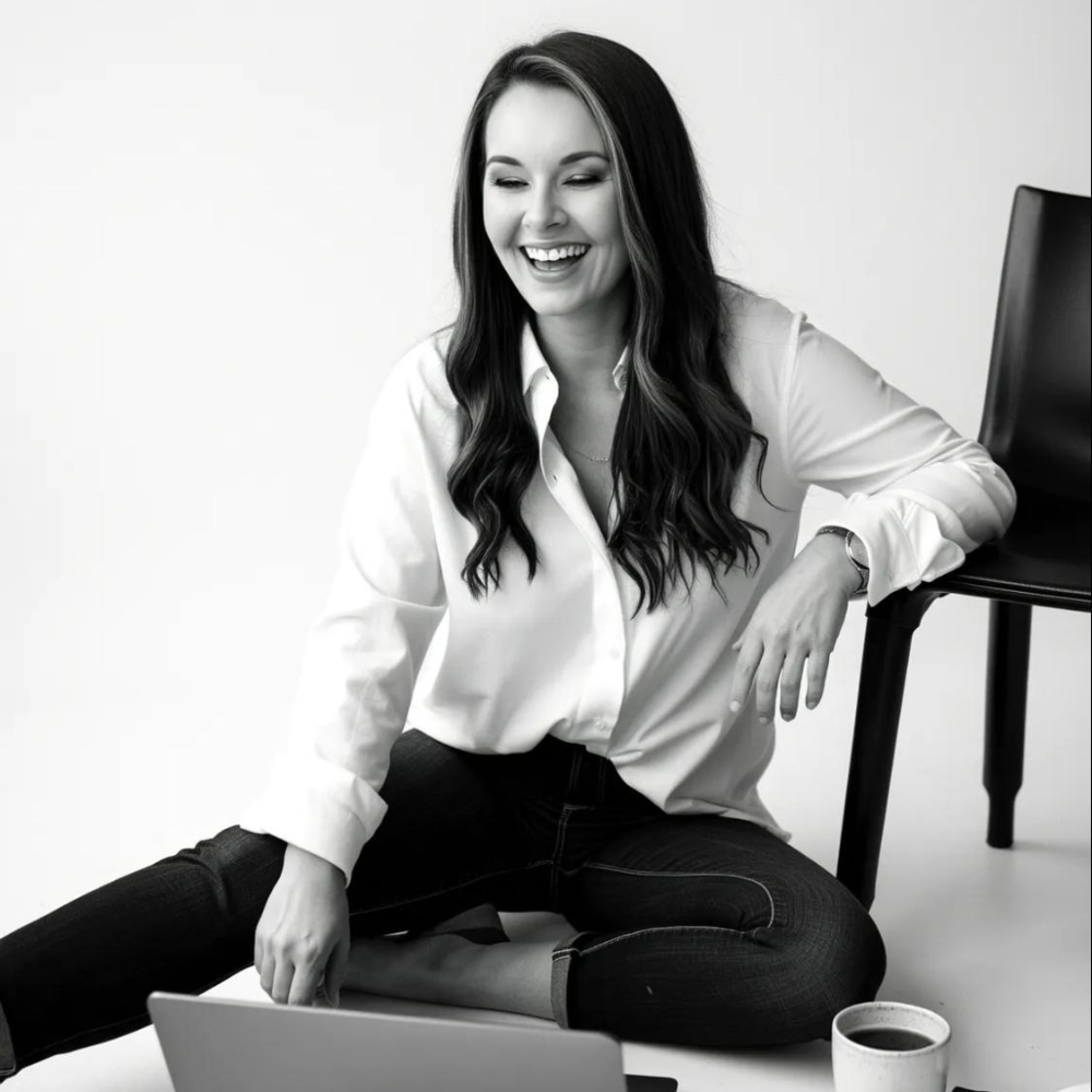 Kinsey, founder of Boutique Bestie Solutions, laughing while working on a laptop